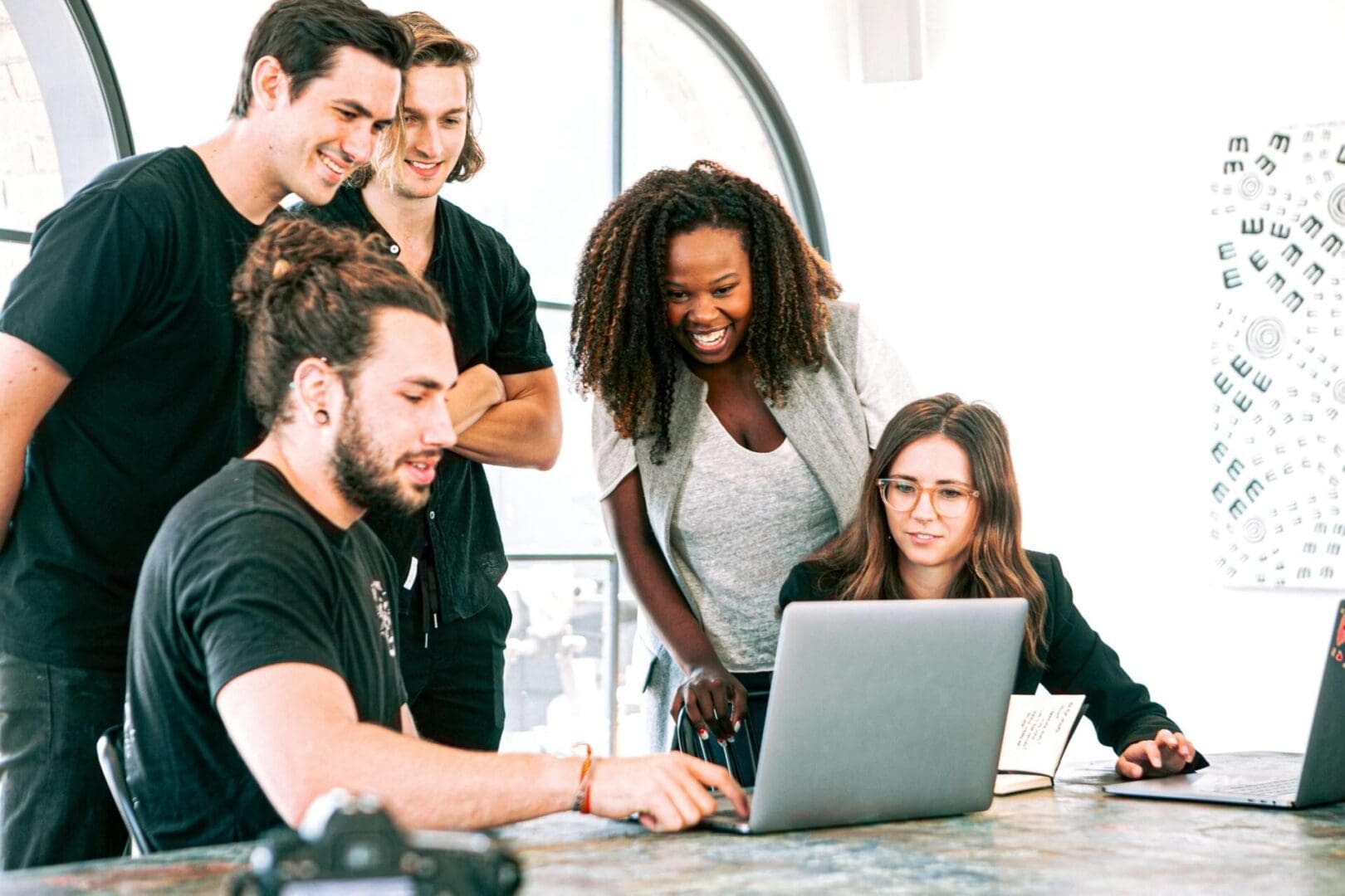 pexels-canva-studio-3153201 A group of people standing around a laptop.